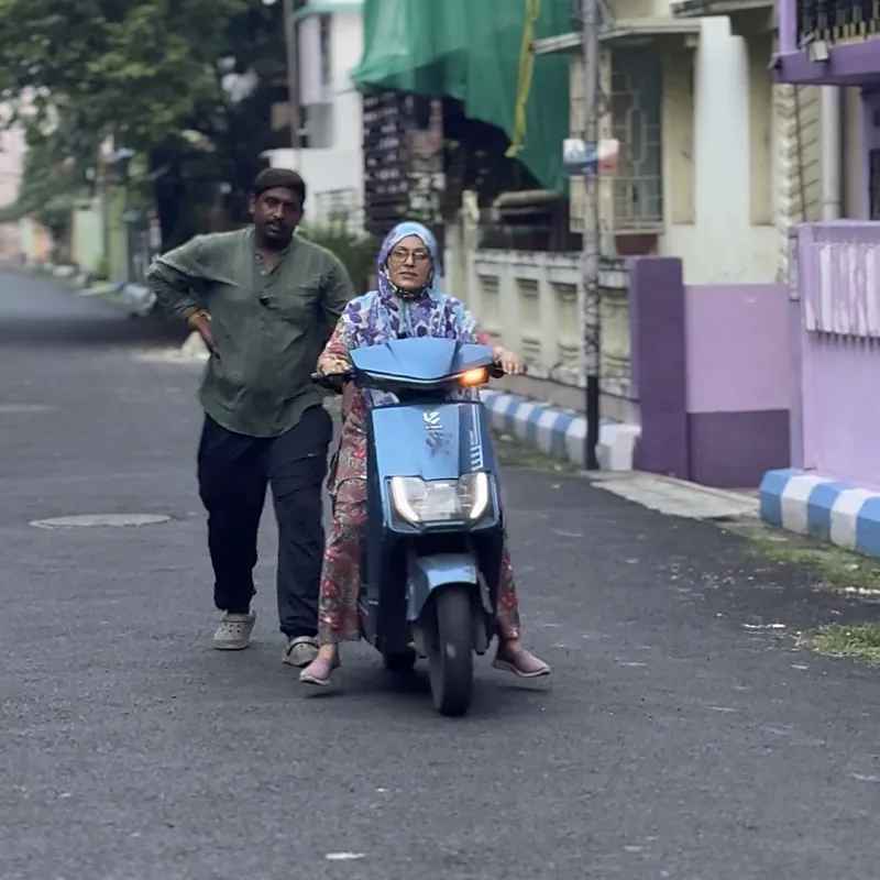 Trainer walking beside a learner on a quiet lane