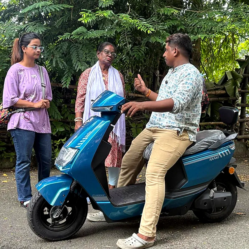 Trainer explaining scooty controls to two learners