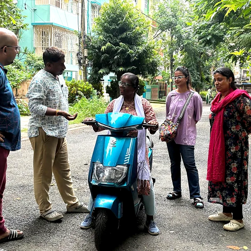 Older learner on a scooty while her family watches the lesson