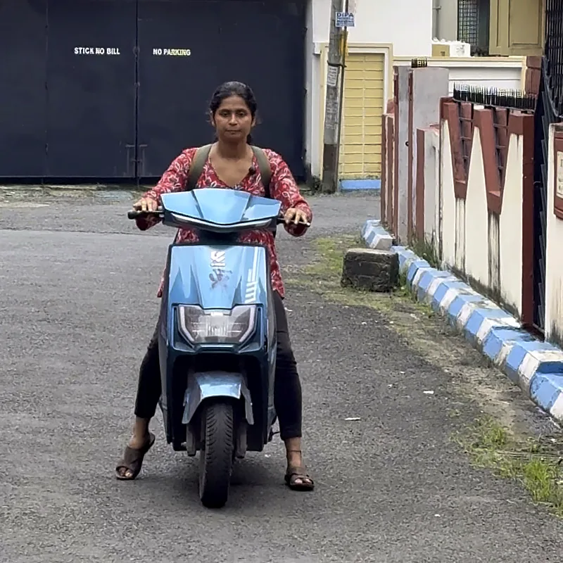 Learner on her first scooty ride, feet ready on the ground