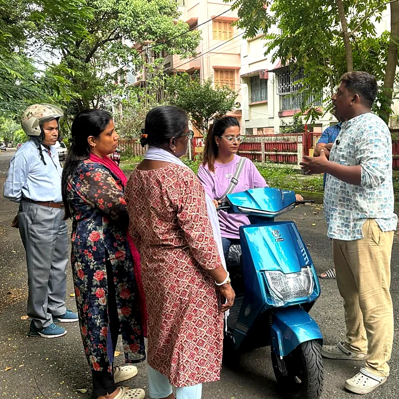 Trainer explaining the scooty controls to a group of learners