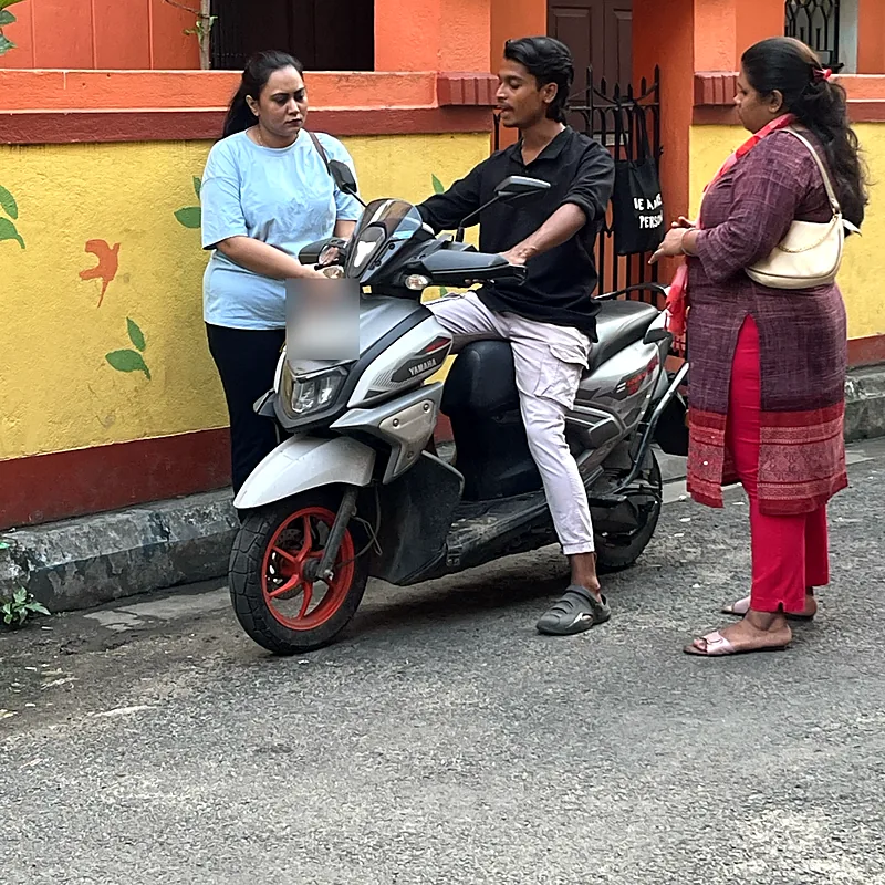 Trainer showing two learners how to handle a scooter